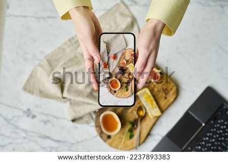 Woman photographing food on her mobile phone