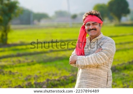 Happy Indian farmer standing at agriculture field. Royalty-Free Stock Photo #2237896489