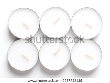 Group of maxi tealights, long-burning tea lights, large tea candles, also known as nightlights. Tea lites, t-lites or t-candles in thin metal cups, so that the wax can liquefy completely while lit. Royalty-Free Stock Photo #2237922135