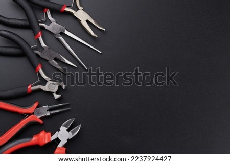 Set of different types of pliers and side cutters isolated on black background. Hand tools for repair, construction and maintenance Royalty-Free Stock Photo #2237924427