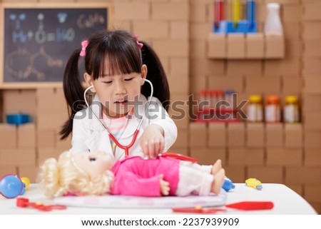 A little girl with doctor s coat pretend be a doctor and playing educational medical game