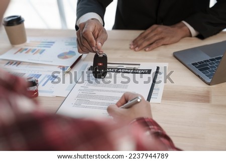 Loan approver, businessman in suit, man giving car keys after car loan approval and contract signing