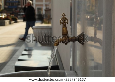 A tap with tiny water coming out of it. High quality photo