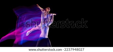 Young man and woman, figure skating athletes dancing isolated over black background in neon with mixed lights. Flyer. Concept of movement, sport, competition, dance, choreography. Copy space for ad