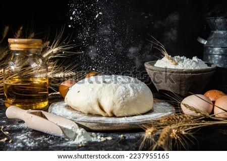 Dough on the table on a dark background.Flour,butter,eggs