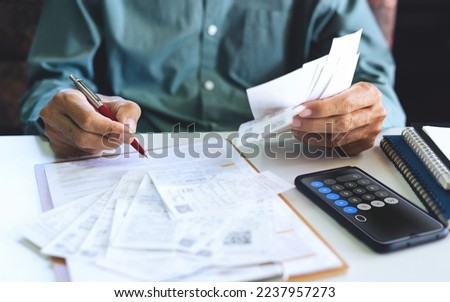 Stressed asian man using smartphone calculating receipt payment, monthly expenses, taxes, bank account balance and , Income is not enough, no money in pocket for expenses Royalty-Free Stock Photo #2237957273