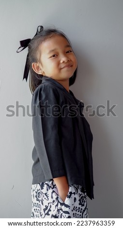 Image of Asian child smiling and posing with traditional dress on grey background