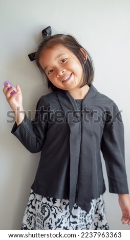 Image of Asian child smiling and posing with traditional dress on grey background