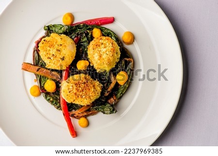 Scallops. Scallops sautéed in olive oil, with crushed almonds, garnished with scallions, parsley and served with organic vegetables. Classic Italian, American restaurant or French bistro entree. Royalty-Free Stock Photo #2237969385