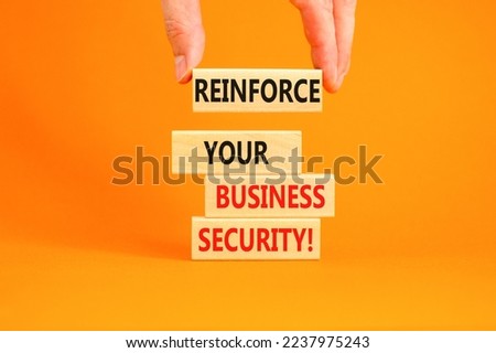 Reinforce your business security symbol. Concept word Reinforce your business security on blocks. Beautiful orange background. Business reinforce your business security concept. Copy space.
