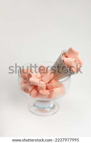in white waffle cones for ice cream gently peach sweet marshmallows on a white background in a transparent glass. for labels, signs, postcards, announcements and more