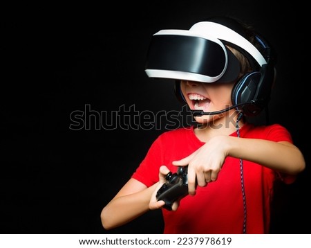 Close up photo of a young girl in VR playing video games with excited face. Photo on dark background. Win.