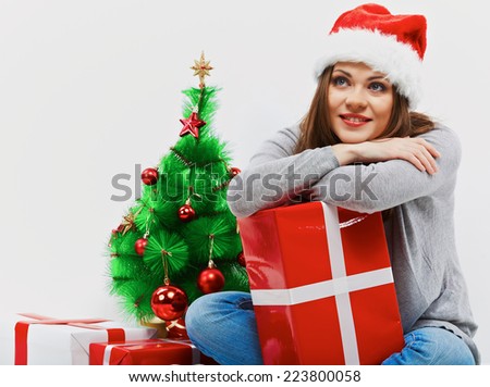 Santa girl isolated portrait with Christmas gift, christmas tree.Young smiling woman.