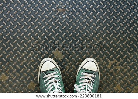 Green sneakers from an aerial view on metal texture. Top view.