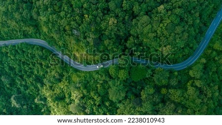 Aerial view of a road in the middle of the forest , road curve construction up to mountain	 Royalty-Free Stock Photo #2238010943