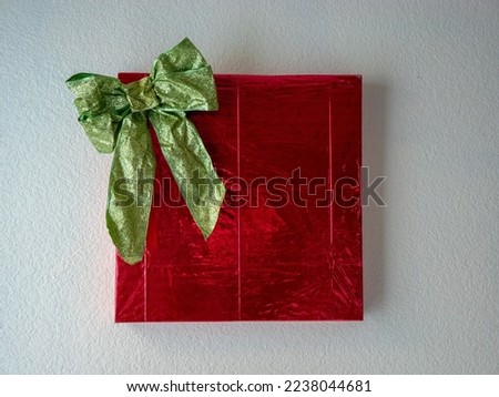 Wall art wrapped for Christmas with a green bow