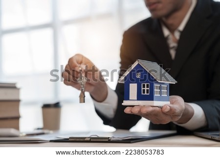 Credit approver, businessman in male suit and house toy model mockup Home loan mortgage approval concept. After signing the contract