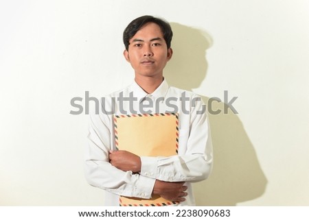 portrait of an Indonesian man in formal wear and holding a brown envelope or job application letter. Asian male facial expression smiling or flat looking at the camera. job seeker illustration