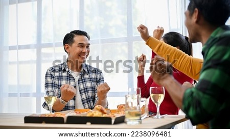 Group of overjoyed Asian friends celebrating, showing clenched fits, having fun time together in the party.
