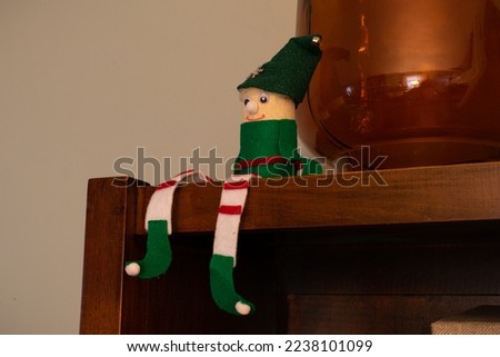 Elf decoration sitting on top of shelf.