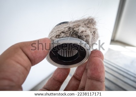 Household vacuum cleaner filter clogging up with dust, mite, hair, and animal fur after an extensive household cleaning : allergy, unhygienic concept Royalty-Free Stock Photo #2238117171