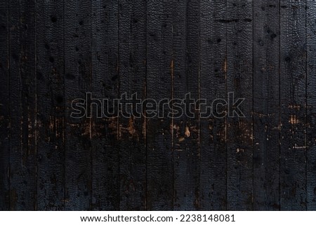 Burnt wooden plank surface after a fire. Details with patterned wood surface texture was charred. Footprint of Fire on Its Surface .Background Texture for use Royalty-Free Stock Photo #2238148081