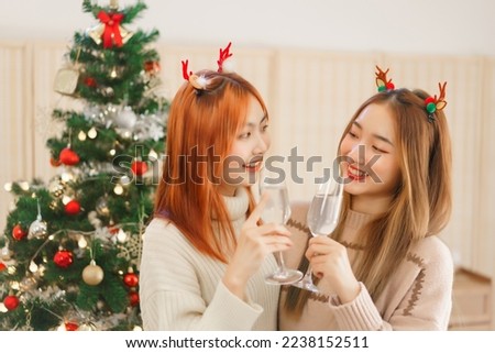 Christmas decoration concept, Two women in reindeer horns drinking champagne to toasting in party.