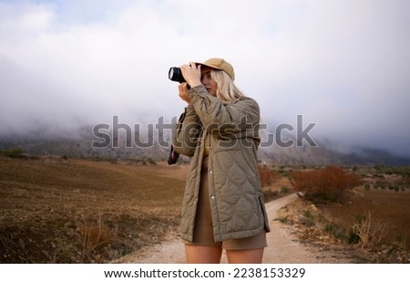 Hiker photographer taking picture of the valley with mountains