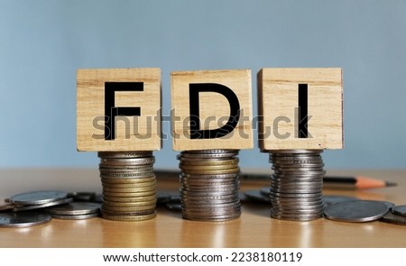 Concept of FDI or foreign Direct Investment on India in wooden block letters on stack of coins.  Royalty-Free Stock Photo #2238180119