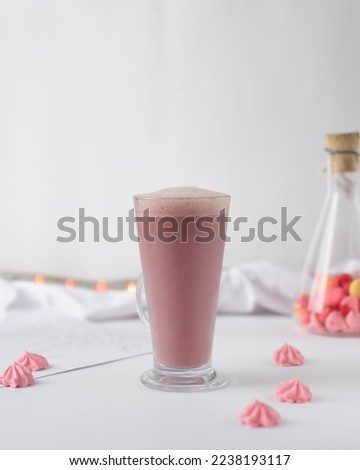 Pink latte in a latte glass, latte in a glass with meringue kisses