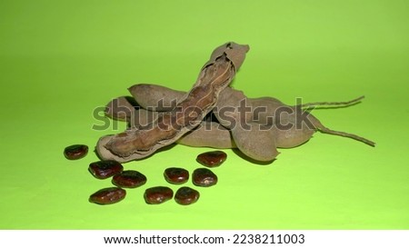 Tamarind fruit with seed isolated on green background with copy space for your text. Top view. Flat lay