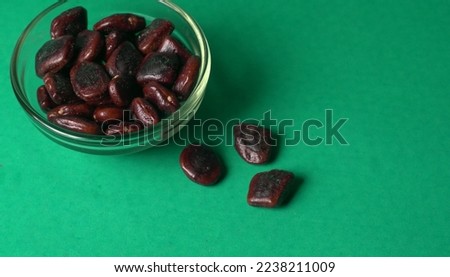 Tamarind fruit with seed isolated on green background with copy space for your text. Top view. Flat lay