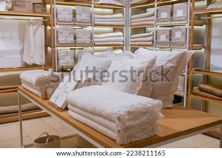 A set of white bedding is on the shelf in the store. Pillow and blanket are for sale Royalty-Free Stock Photo #2238211165