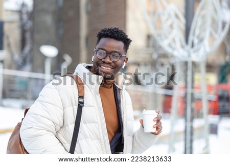 Street portrait of a young businessman holding a cup of coffee