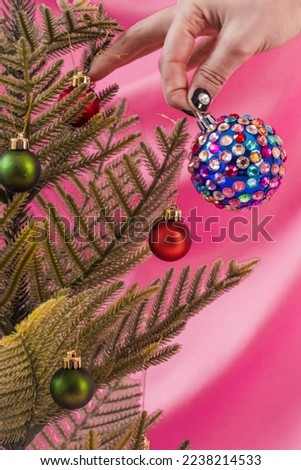 Colorful Christmas tree with colored spheres on pink backdrop