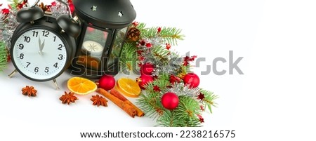 Christmas decor: alarm clock, lantern, spruce twigs, Christmas balls isolated on a white background. There is a place for the text of congratulations. Wide photo.