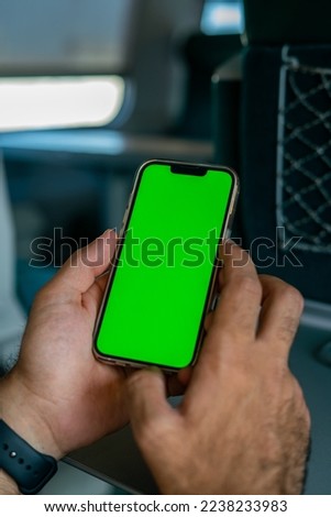 Unidentified man holding a smartphone with green screen