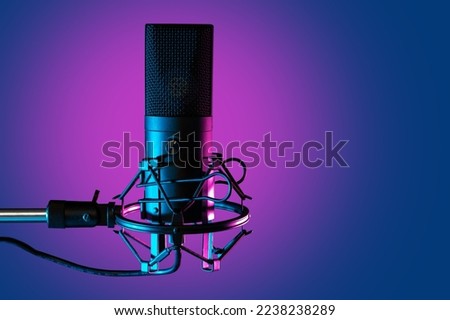 Concert microphone close-up. Mike is mounted on tripod. Condenser mike for concert. Microphone for singer or event host. Condenser mike on purple. Sound equipment. Modern voice recording device