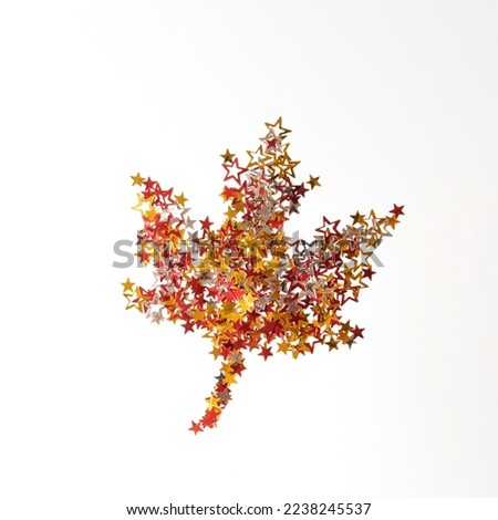 Creative layout of colorful autumn leave made of stars confetti. Flat lay. Season concept.