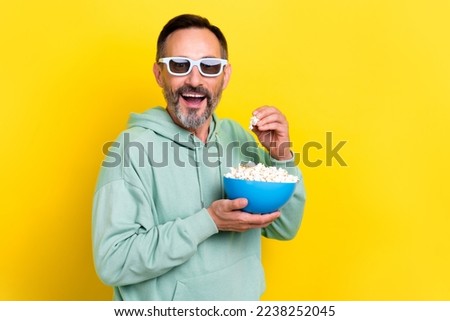 Photo of eating popcorn old retired brunet hair mature age man wear khaki sweatshirt open mouth look new premiere isolated on yellow color background