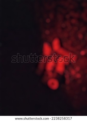 blurred close up photo of cigarette butts under red light
