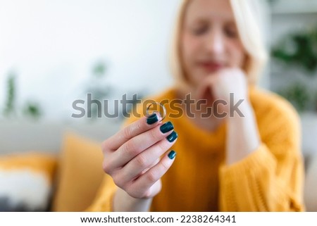 Young woman holding wedding engagement ring in hands, engaged girl doubts about marriage proposal, abandoned wife depressed after getting divorced, help to overcome breaking up, starting new life Royalty-Free Stock Photo #2238264341