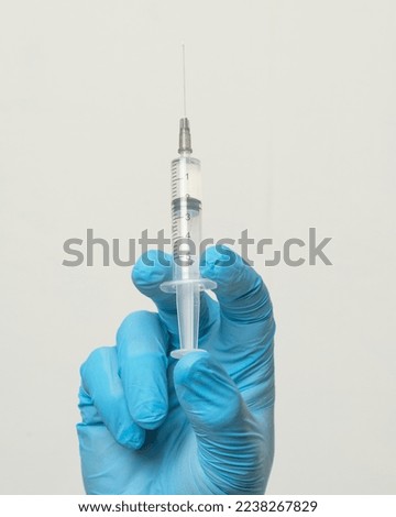 syringe in the doctor's hand on a blue background