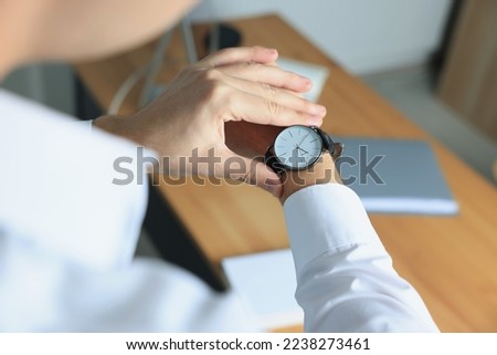 Man checking time in office, closeup. Being late Royalty-Free Stock Photo #2238273461