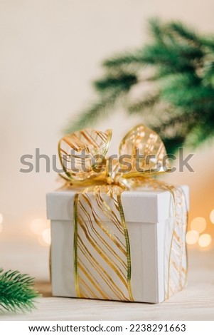 Festive sparkling christmas gift box for xmas holiday present with garland and candles light on the background