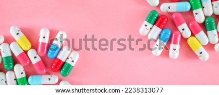 Colorful medical pills with funny faces on light pink background top view. Funny medical banner with copy space