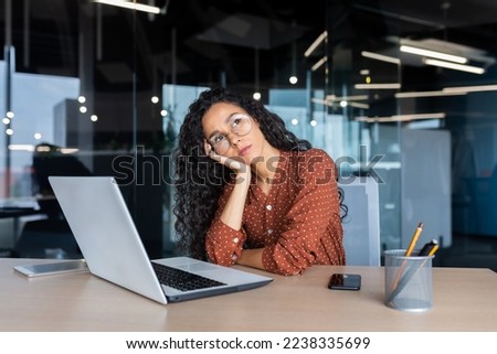 Boring work, hispanic woman working inside office, business woman working at desk using laptop at work. Royalty-Free Stock Photo #2238335699
