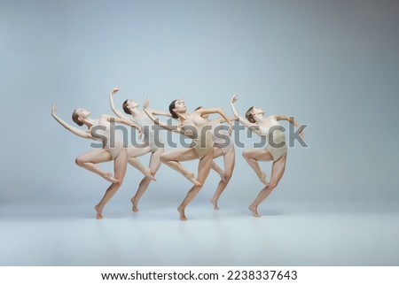 Group of young girls, ballet dancers performing, posing isolated over grey background. Flexibility, attraction, grace. Concept of art, beauty, aspiration, creativity, classic dance style, elegance Royalty-Free Stock Photo #2238337643