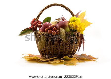 Autumn fruits with yellow leaves in a basket isolated on white