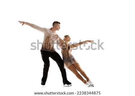 Portrait of young man and woman, figure skating athletes performing isolated over white studio background. Coordinated movements. Concept of movement, sport, beauty, hobby, competition. Ad